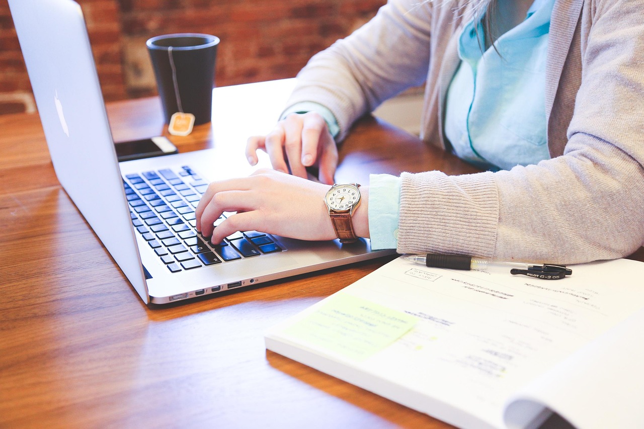 Man zit aan verstelbaar bureau, ergonomisch thuiswerken. Man zit aan verstelbaar bureau, ergonomisch thuiswerken.